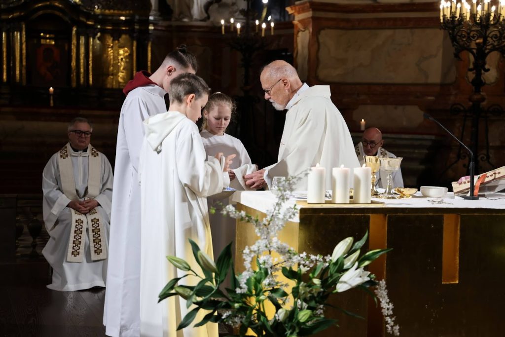 Švęstu vandeniu plaunamos kunigo rankos